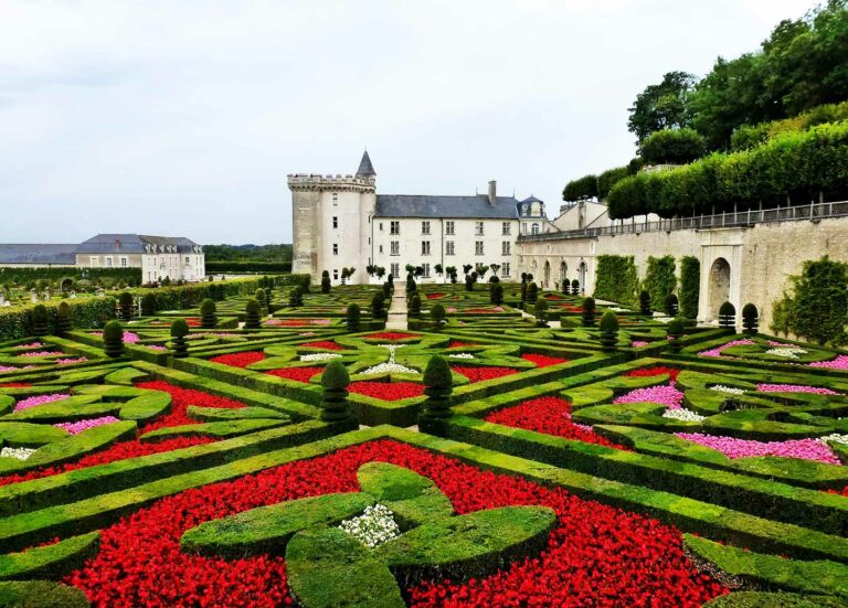 Breathtaking view of the ornate gardens at Château de Villandry, showcasing symmetrical patterns and vibrant floral arrangements, with the historic castle in the background, France.