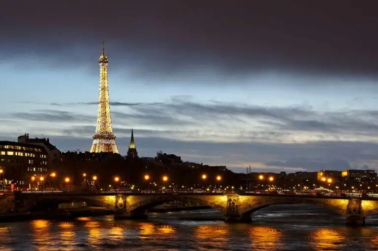 eiffel tower illumanted at night over the city landscape.