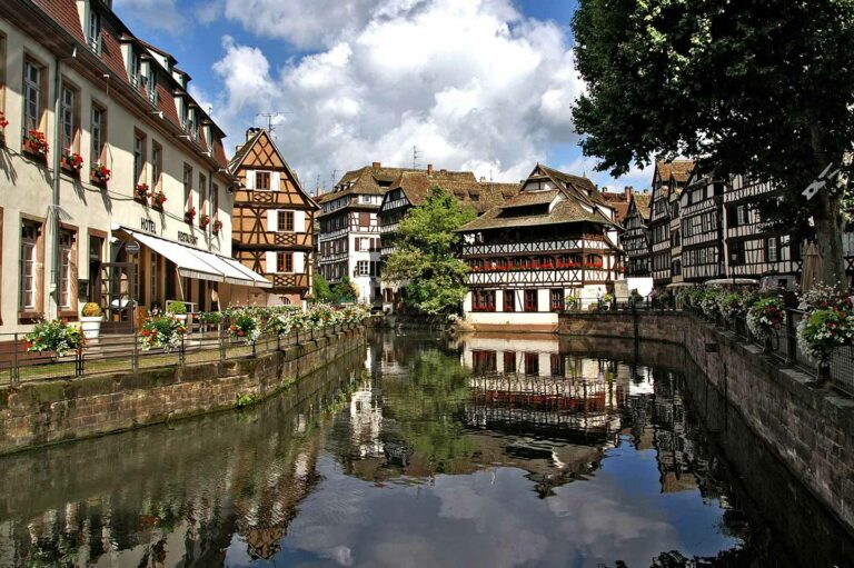 water canal in strasbourg with beautiful 13th century architecture on buildings in the background.