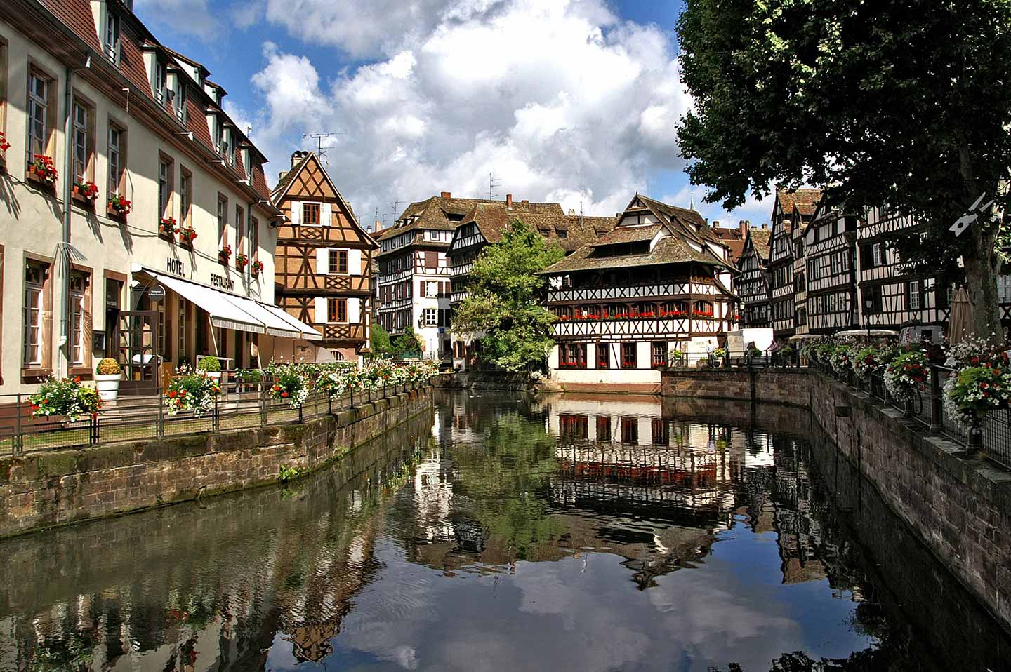 water canal in strasbourg with beautiful 13th century architecture on buildings in the background.