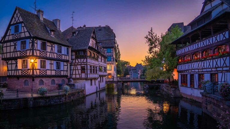 evening picture with medieval wooden framed buildings either side of the canal in Strasbourg