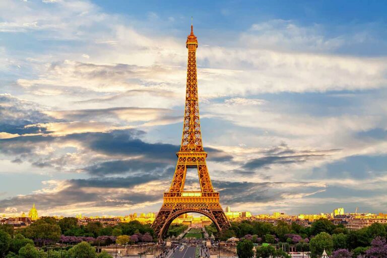 Breathtaking view of the Eiffel Tower in Paris, France at sunset with colorful sky and cityscape