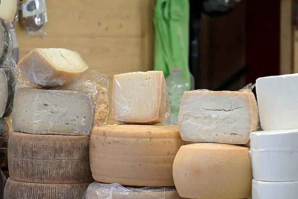 Guide showing people around a French Cheese market on tour.