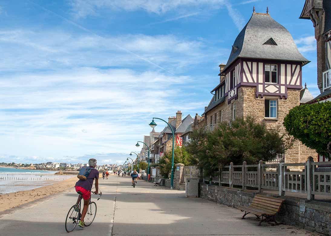 Cyclist on tour at beachfront in St Malo, France.