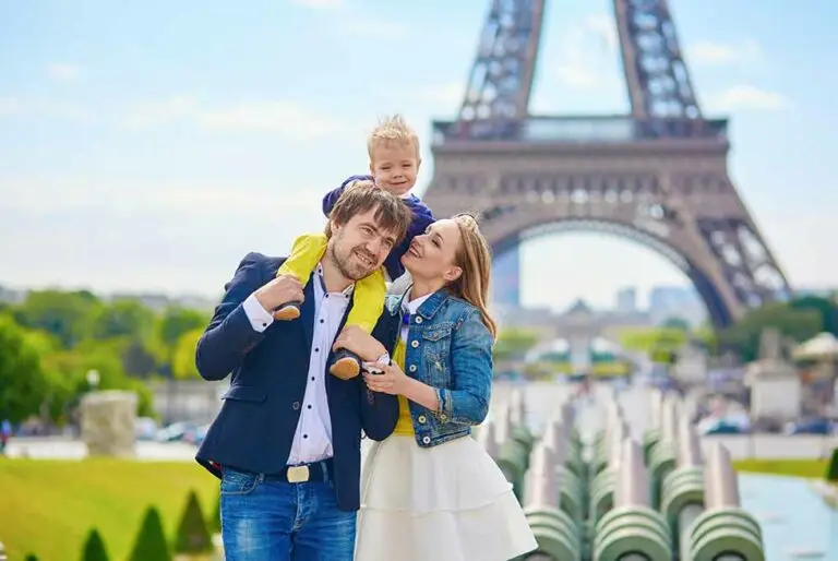 Happy family of three in Paris, France with Eiffel tower in the background