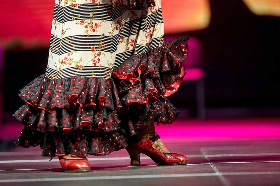 Close-up of Flamenco dancer's elaborate skirt and traditional red shoes performing on stage in Madrid, Spain