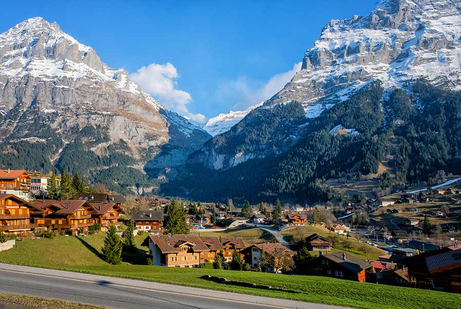 Scenic view of Grindelwald village with traditional Swiss chalets and the snow-capped Eiger mountain in the Swiss Alps, perfect for travel and tourism in Switzerland