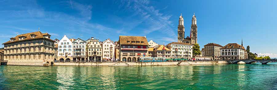 Panoramic view of the Old Town in Zurich, Switzerland showing historical buildings and the Grossmünster along the Limmat River