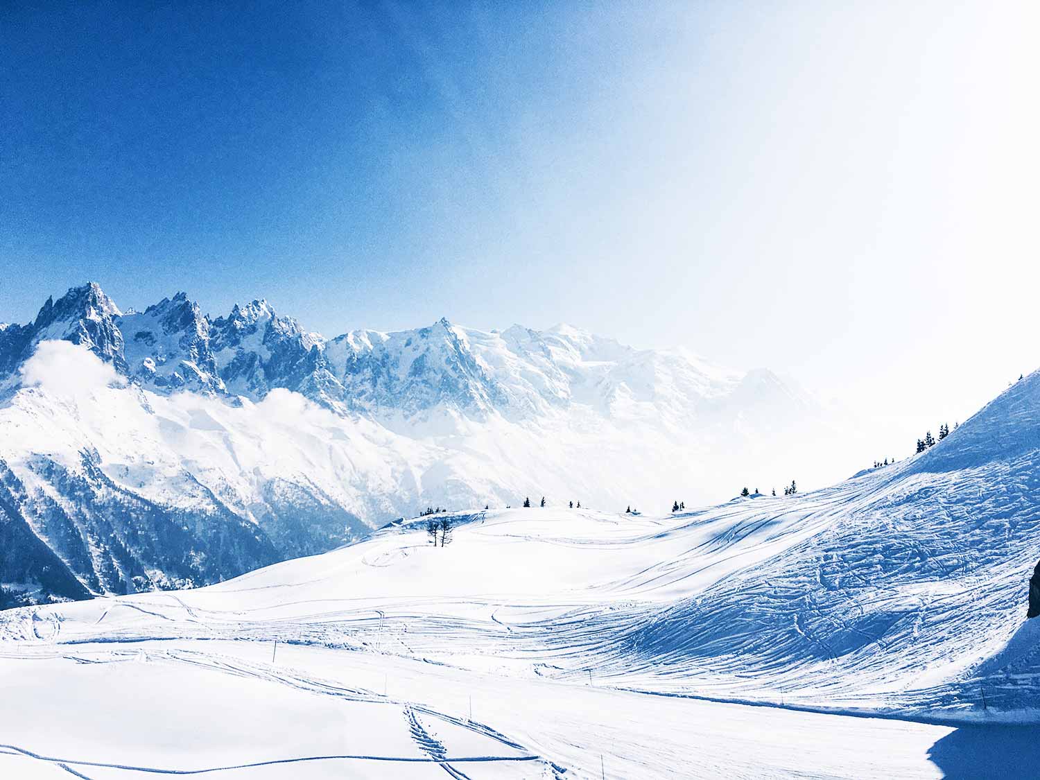 Breathtaking view of snow-covered peaks and ski slopes in Chamonix, French Alps, ideal for winter sports and tourism in France.
