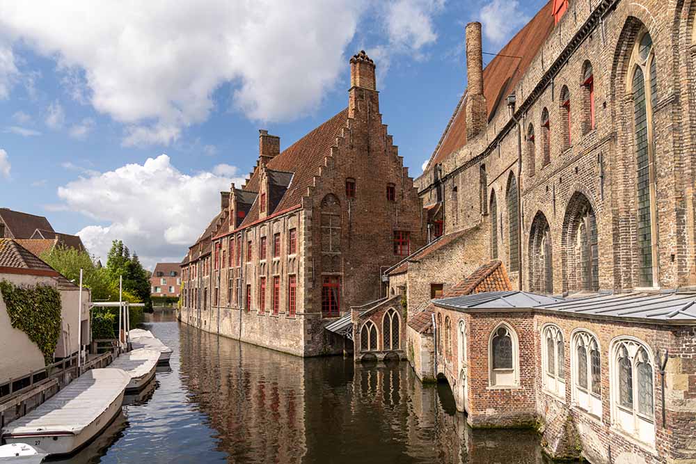 Scenic view of the historic center and canals of Bruges, Belgium with medieval buildings and boats.